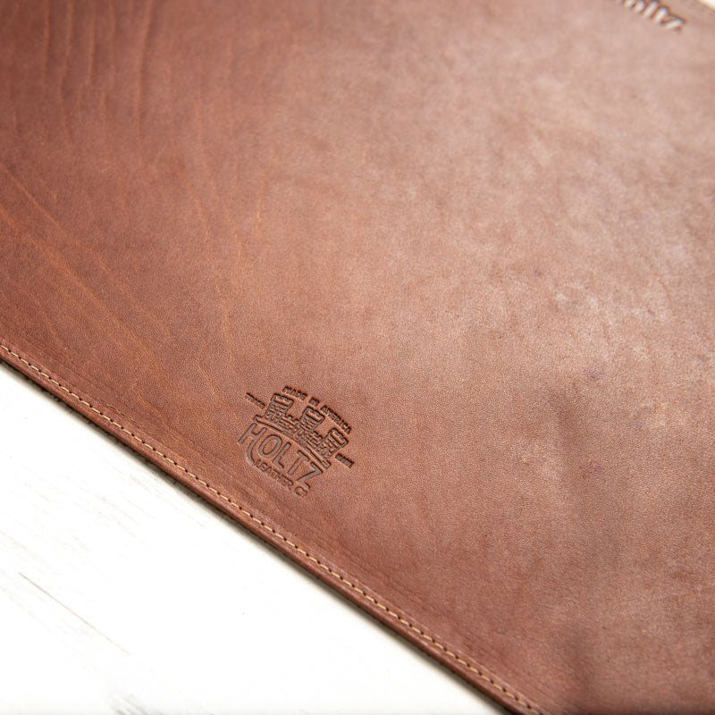 Beveled edge personalized fine leather placemat in rich brown with embossed detailing.