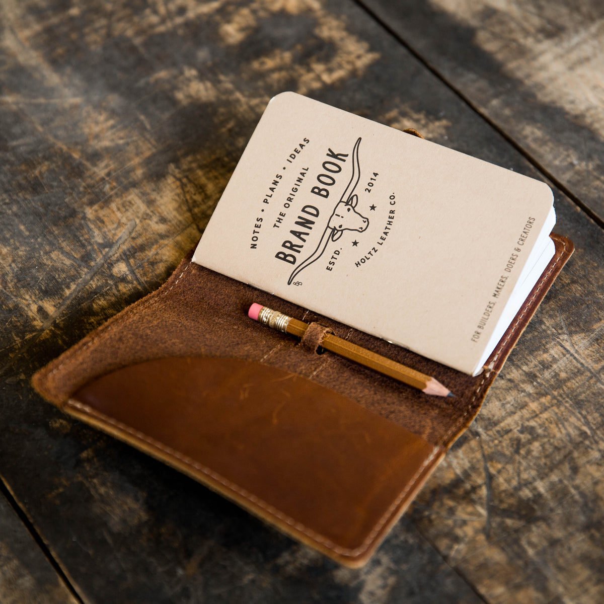 Crimson Tide leather pocket journal cover with a pencil and a brand book inside.